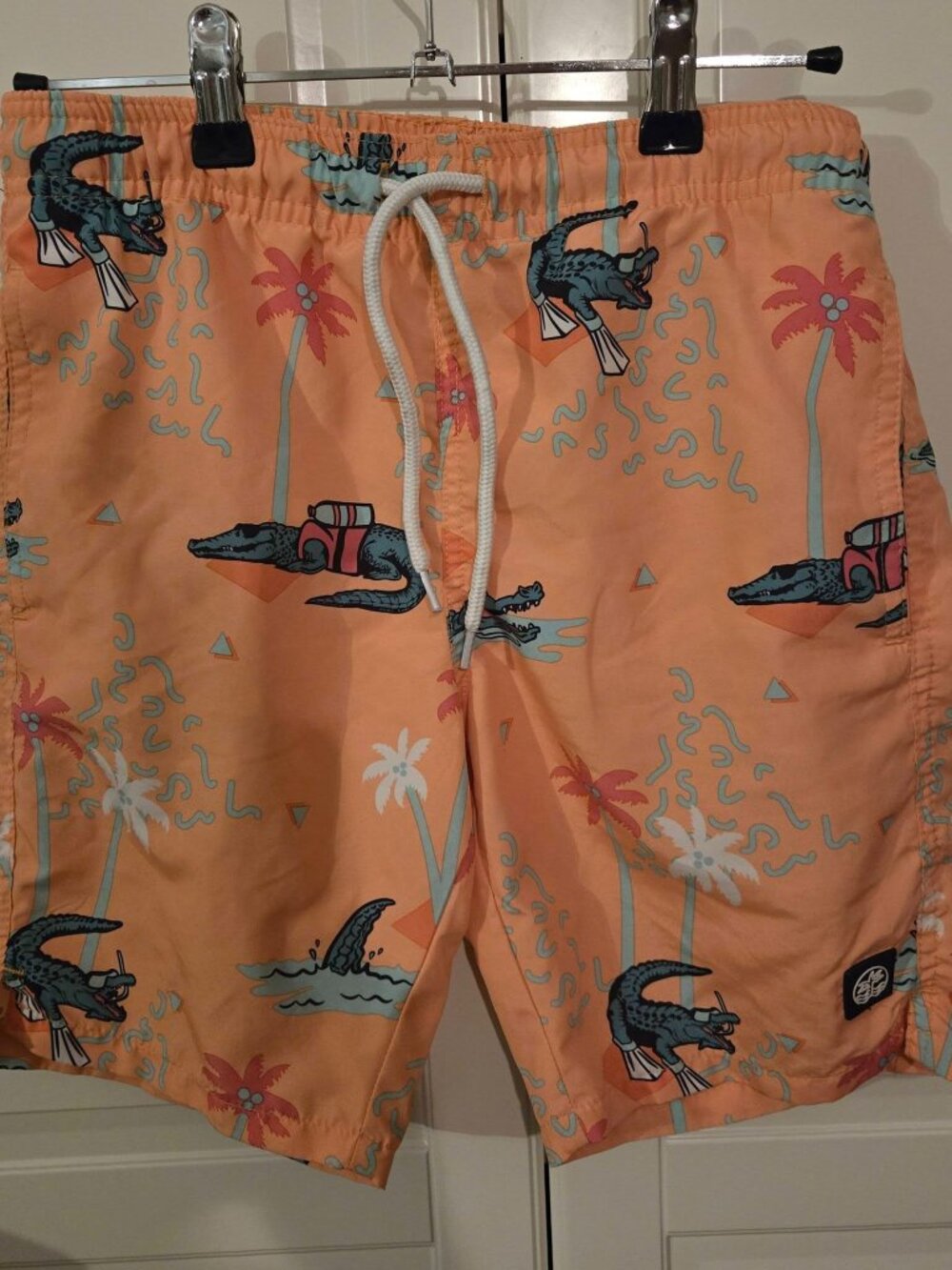 Swim shorts, size 10–12 years; features side pockets and a back pocket.